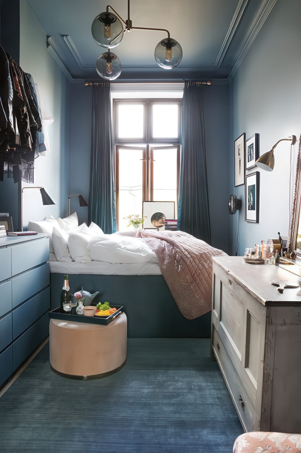 a small vintage-inspired bedroom with grey walls, a catchy chandelier, a storage bed and dresser, a makeshift closet