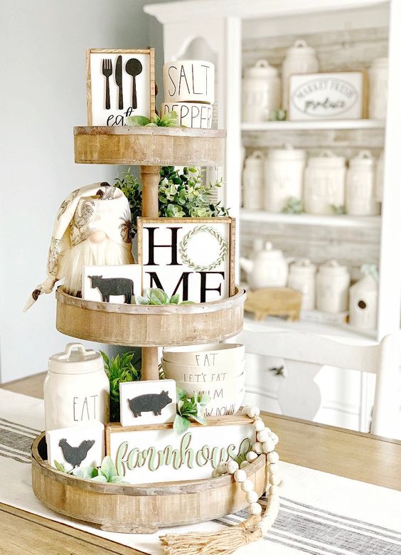 a spring farmhouse stand with greenery, beads, funny artworks of wood and a little gnome for kitchen decor
