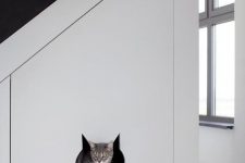 a staircase with a built-in cat toilet – it’s a large sleek drawer with a cat head entrance is perfect for a minimalist space