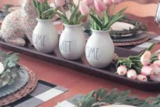 a tray with a floral bunny, pink tulips in vases and greenery wreaths for each place setting feel spring-like