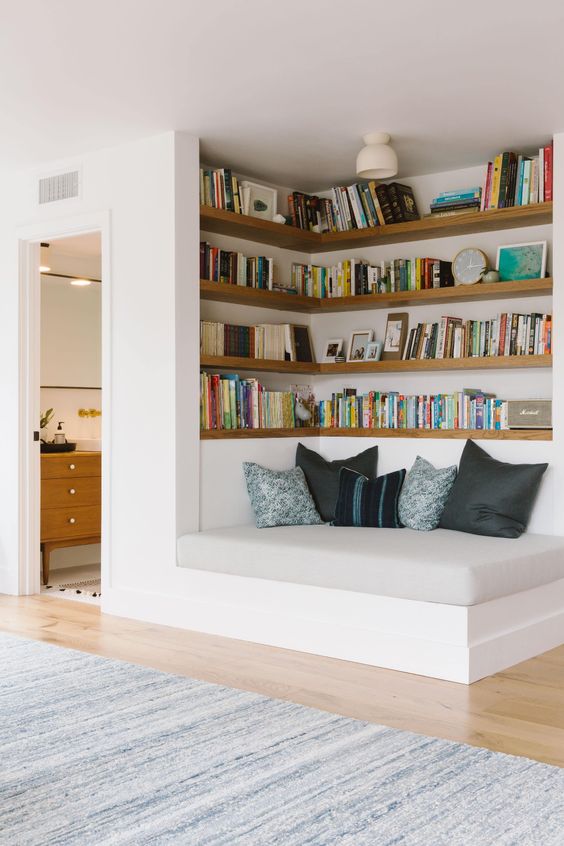 a welcoming nook with built-in shelves and a comfy daybed is a cool space to spend some time reading and relaxing