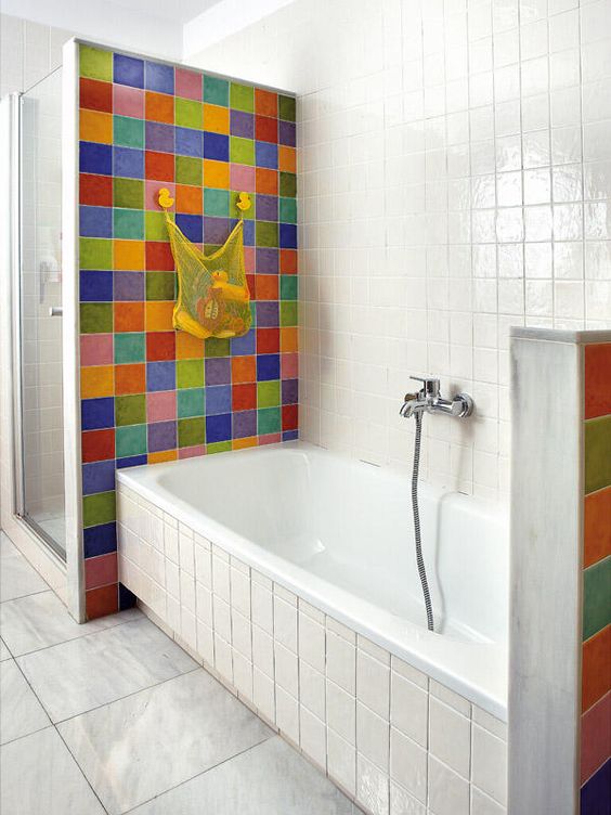 a white bathroom accented with super bold and bright tiles around the bathtub to highlight this space and make it outstanding