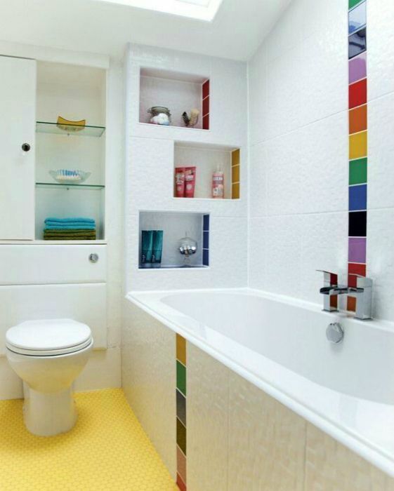 a white bathroom with colorful tiles accenting the walls and shelves, a yellow floor and a skylight is a pretty and mood-raising idea