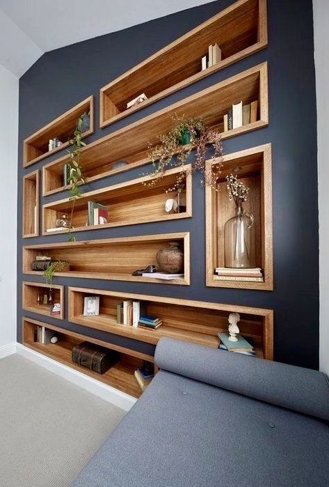 bookshelves and niches built into a wall contrast it and make the use of this blank wall