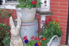 bright blooms in galvanized buckets, a bunny statue and a bird house for a rustic vintage spring porch