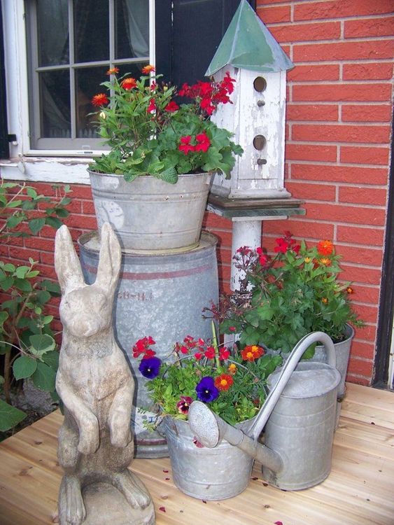 bright blooms in galvanized buckets, a bunny statue and a bird house for a rustic vintage spring porch