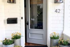 colorful blooms in galvanized buckets will make your porch feel rustic and spring-like