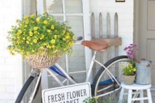 colorful potted and basket blooms, a fake flower wreath and a watering can for a spring porch