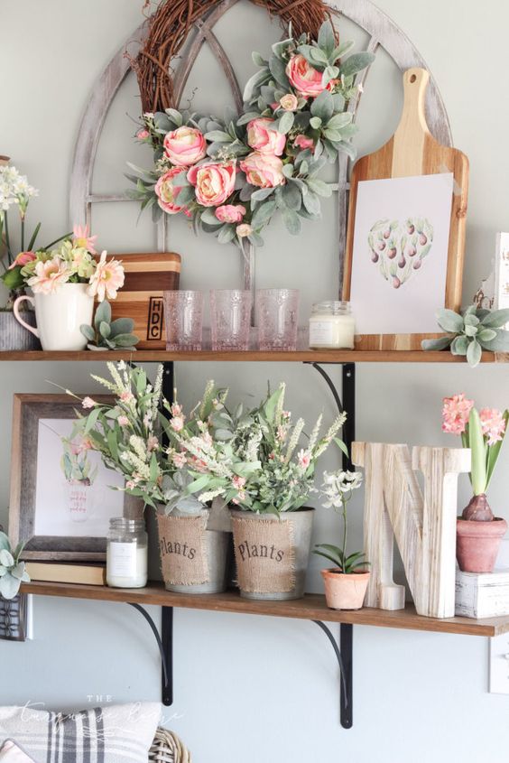 fake pink blooms and greenery, succulents, fresh blooms in pots and pink glasses add a spring touch
