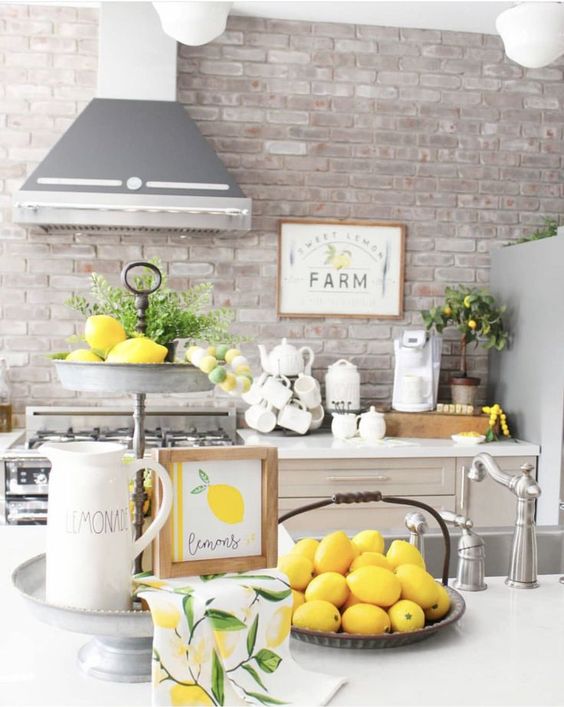 lemons in a bowl, a stand with lemons, greenery and an artwork make the kitchen feel farmhouse spring-like