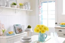 light blue linens, a jug with yellow blooms and some yellow touches make the kitchen spring-like
