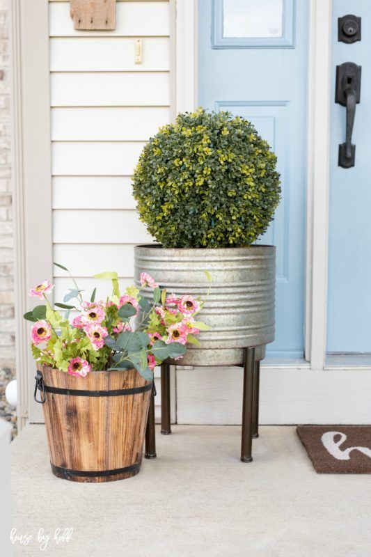 potted fake blooms and greenery and a boxwood topiary will make your porch look fresh and spring
