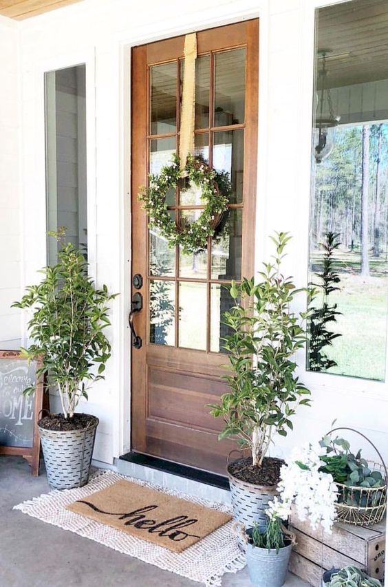 potted greenery, a greenery and white bloom wreath, some blooms in buckets for stylish and fresh spring decor