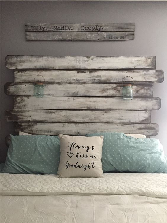 a bedroom with grey walls, a bed with a whitewashed headboard, white and aqua bedding, a sign is a lovely idea for shabby chic lovers