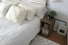 a neutral farmhouse bedroom with a bed with a whitewashed headboard, stained nightstands, neutral bedding and artwork, sconces