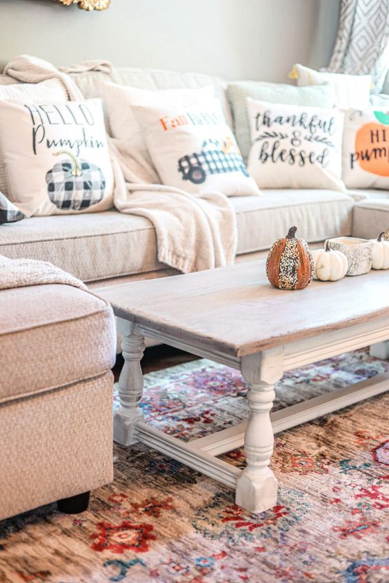 a neutral sectional and a whitewashed low coffee table plus plaid pillows make up a chic and lovely farmhouse space