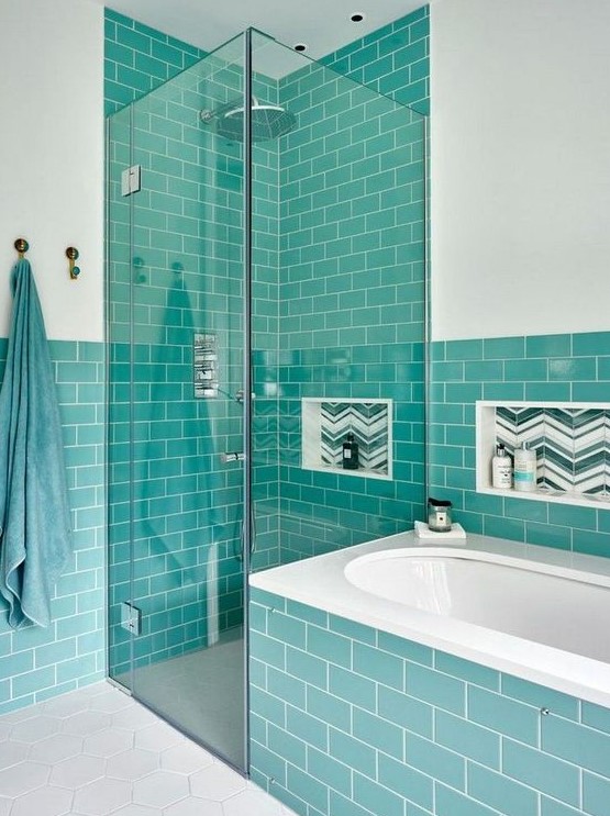 a stylish modern bathroom in white and with turquoise tiles looks contrasting and bright, and niches in the wall are done with green and white tiles, too