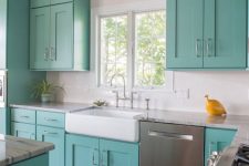 a stylish turquoise kitchen with shaker style cabinets, neutral countertops and a white tile backsplash, stainless steel appliances is cool