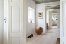 a unique space with white walls, a whitewashed floor, statement furniture and artworks plus lots of light