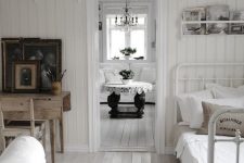 a vintage-inspired home with white walls and a whitewashed floor, with vintage furniture and dark accessories