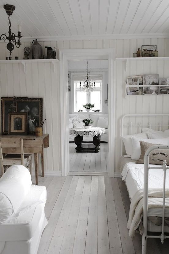 a vintage-inspired home with white walls and a whitewashed floor, with vintage furniture and dark accessories