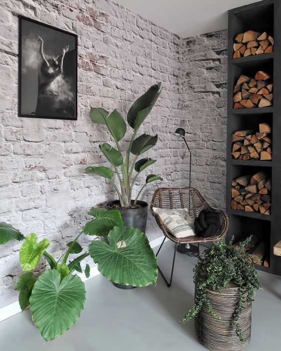 a welcoming nook for reading with whitewashed brick walls, a built-in firewood storage, potted plants is very cool