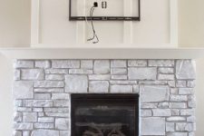 a whitewashed stone fireplace with a white mantel and a built-in fireplace looks very cozy and very natural