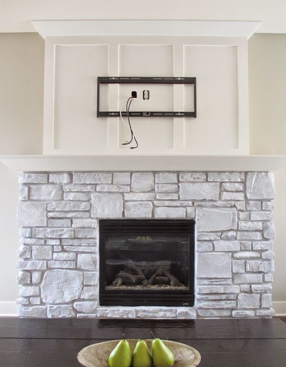 a whitewashed stone fireplace with a white mantel and a built-in fireplace looks very cozy and very natural