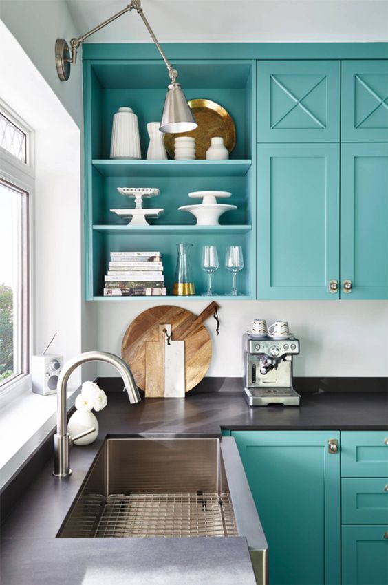 an elegant and chic turquoise kitchen with dark brown countertops, metallic sconces and stainless steel appliances is amazing