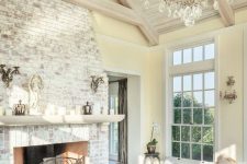 an elegant whitewashed brick fireplace with a refined metal screen, a white mantel with candles for a vintage farmhouse interior