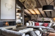 a contemporary chalet living room with a wooden ceiling, a fireplace, neutral seating furniture and a cluster of lovely pendant lamps