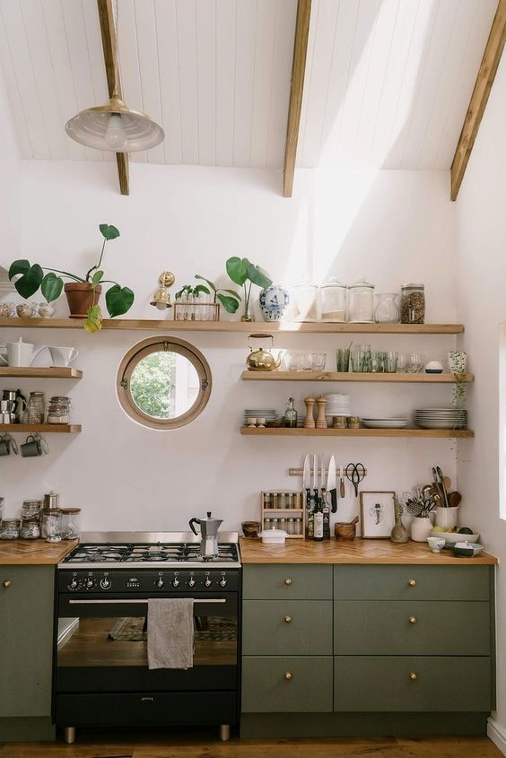 a cozy olive green kitchen with chevron stained butcherblock countertops and matching floating shelves