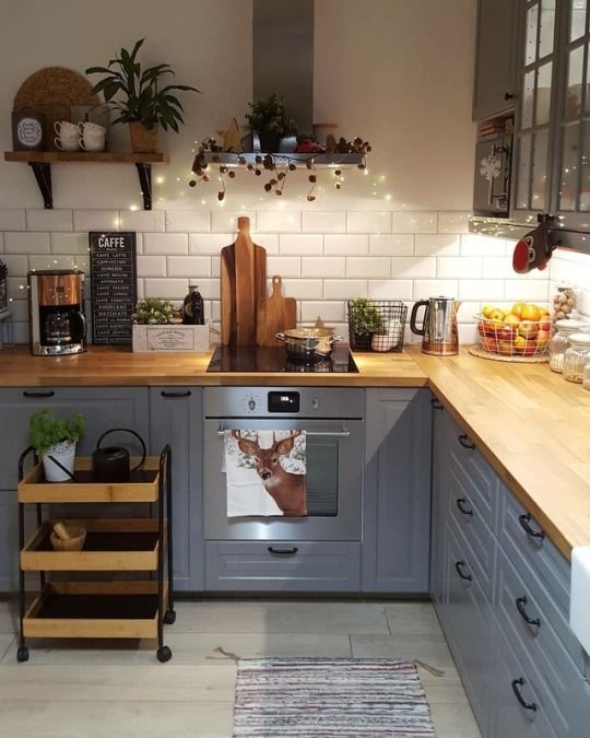 a light blue kitchen with light stained butcherblock countertops and a white tile backsplash looks stylish and chic