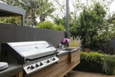 a minimalist bbq area of wooden planks and a concrete countertop plus a grill