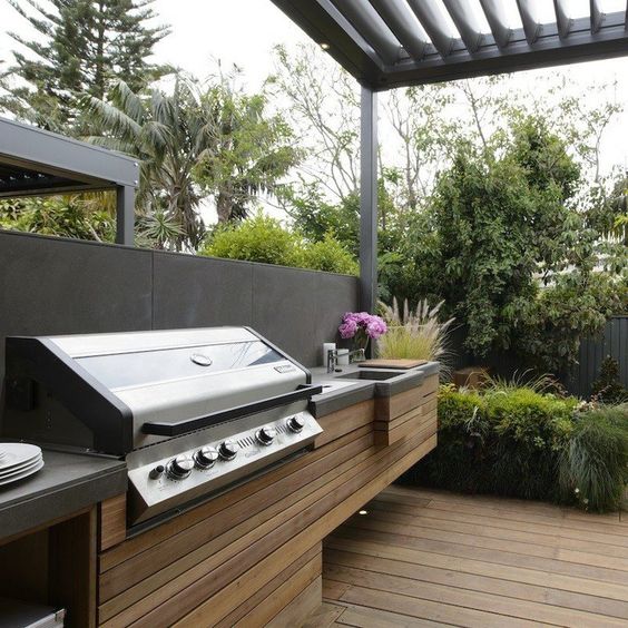 a minimalist bbq area of wooden planks and a concrete countertop plus a grill