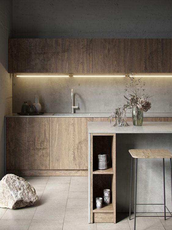 a minimalist plywood kitchen with sleek cabinets, a concrete backsplash and countertops plus a concrete kitchen island