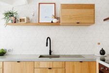 a modern white kitchen with a catchy tile backsplash and light-colored wooden cabients plus concrete countertops