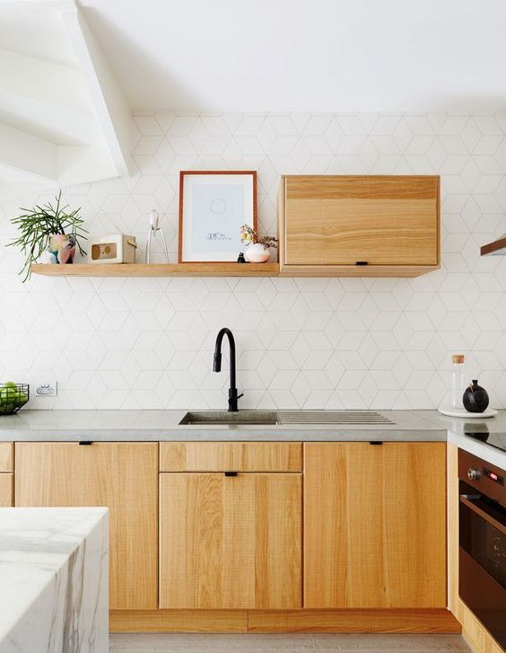 a modern white kitchen with a catchy tile backsplash and light-colored wooden cabients plus concrete countertops