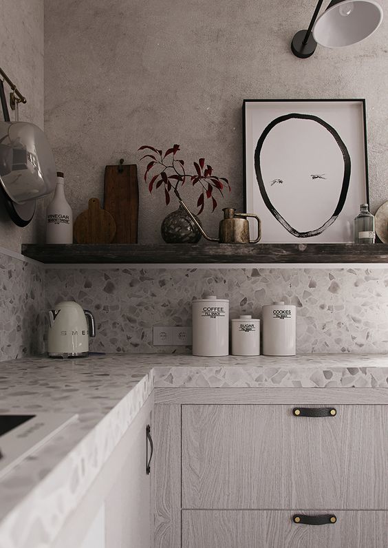 a neutral terrazzo countertop perfectly compliments the whitewashed kitchen cabinets and adds interest