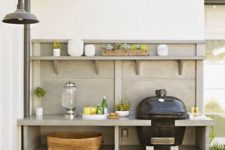 a simple and comfortable outdoor bqq zone with a grill, soem cooking space and firewood stored