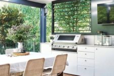 a simple modern outdoor dining space with a white table and rattan chairs plus a grill