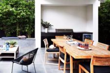 a stylish contemporary dining space done with wooden chairs, a wooden table and blakc upholstery, a black grill next to it