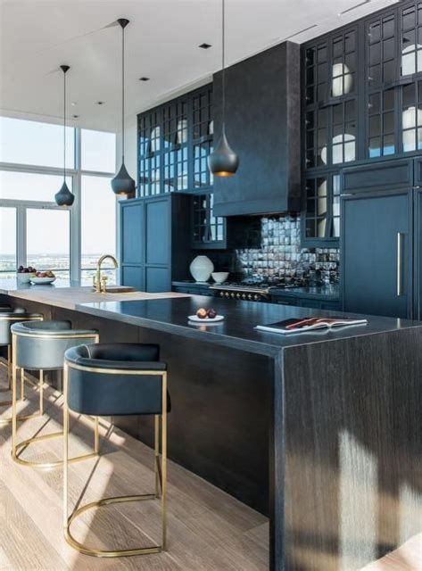 a stylish dark wood kitchen countertop matches the moody kitchen with black glossy tiles and adds chic to the space