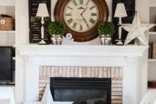 a vintage summer mantel with dark shutters, white lamps, a clock, potted greenery and large wooden stars