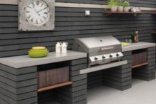 an elegant outdoor bbq area of module concrete blocks, with a large cooking space and a grill plus a clock