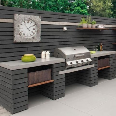 an elegant outdoor bbq area of module concrete blocks, with a large cooking space and a grill plus a clock