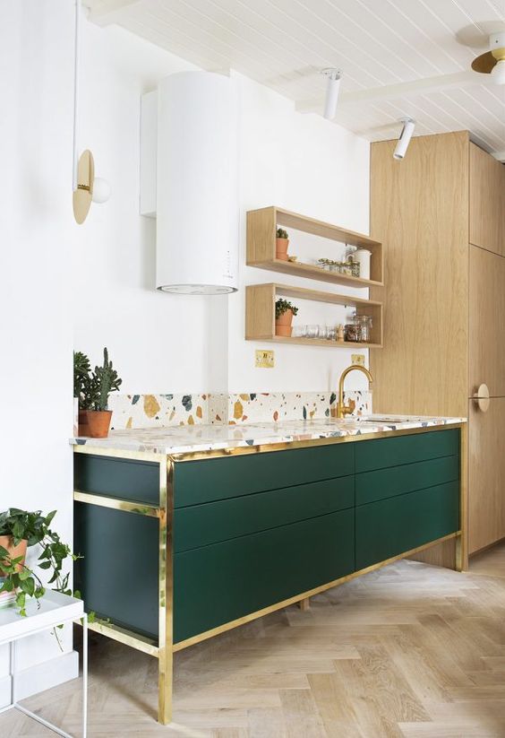 an emerald cabinet with gold touches and a colorful terrazzo countertop looks very chic and catchy