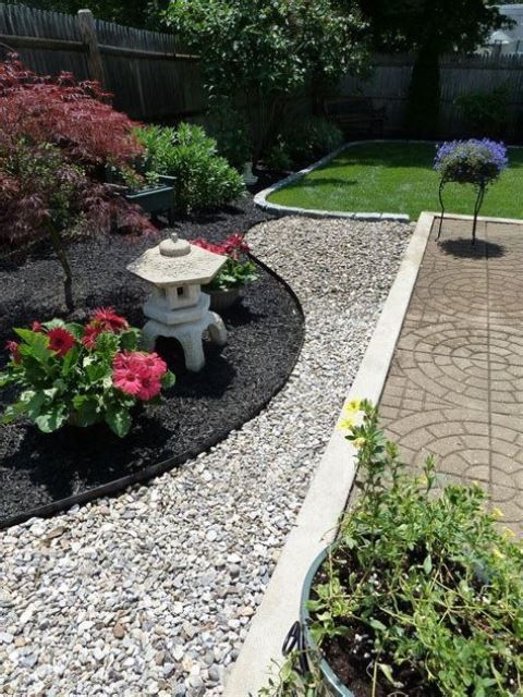 guijarros blancos y negros, flores llamativas, arbustos y mini arces para un elegante jardín delantero japonés