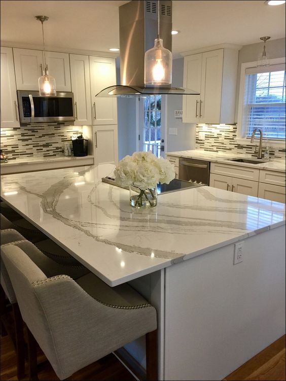 elegant neutral stone countertops complement the white kitchen and make it bolder and more eye-catching