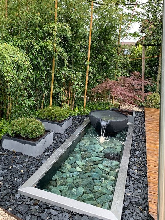 pebbles and rocks, a stone fountain, grasses in flower beds are amazing to complete a zen-like front yard